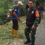 Babinsa Kadudampit Koramil 09/Cisaat Gelar Kerja Bakti Pembersihan Rumput Liar di Bahu Jalan