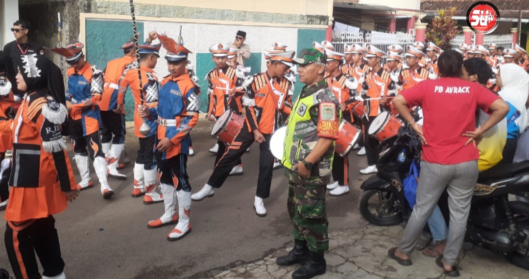 Babinsa Bersama Aparat Pemerintah Desa Sukasari, Laksanakan Pengamanan Pawai Drum Band Kelaikan Kelas MI Radhautal Alfal